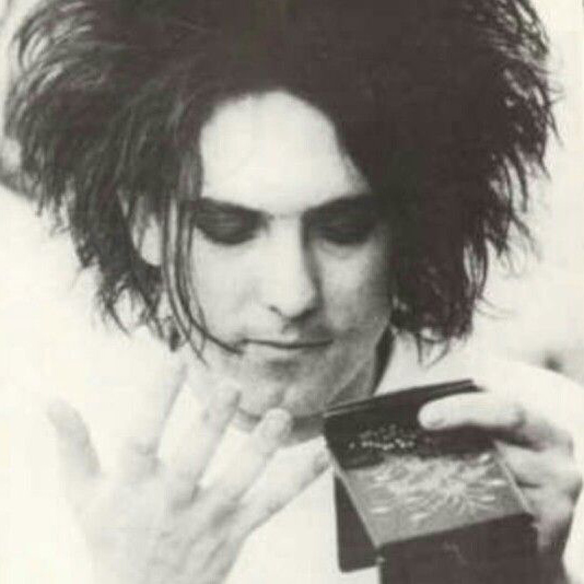 A young Robert Smith puts on his makeup